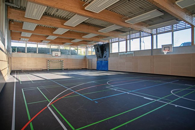 Moderne Turnhalle mit Kletterwand, Basketballkörben und Fußballtoren