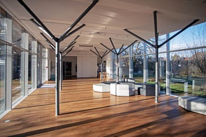 Lichtdurchfluteter Glasdurchgang mit Sitzgruppe