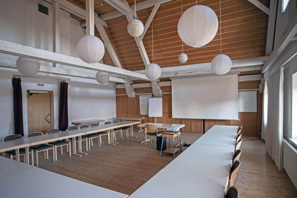 Ein bestuhlter Gruppenraum mit Beamer