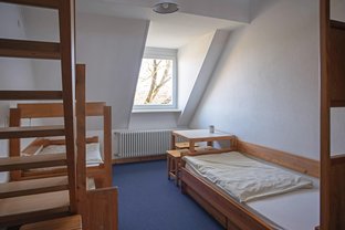 Übernachtungsraum mit zwei Betten und einer Sitzgruppe