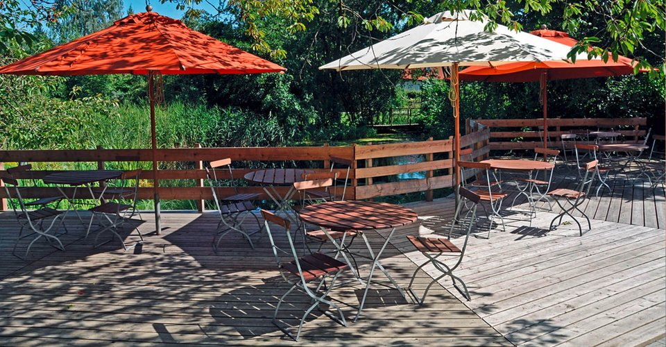 Holzterasse der JuBi mit Sonnenschirmen und Sitzgelegenheiten